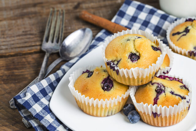 Blueberry muffins with powdered sugar and fresh berries